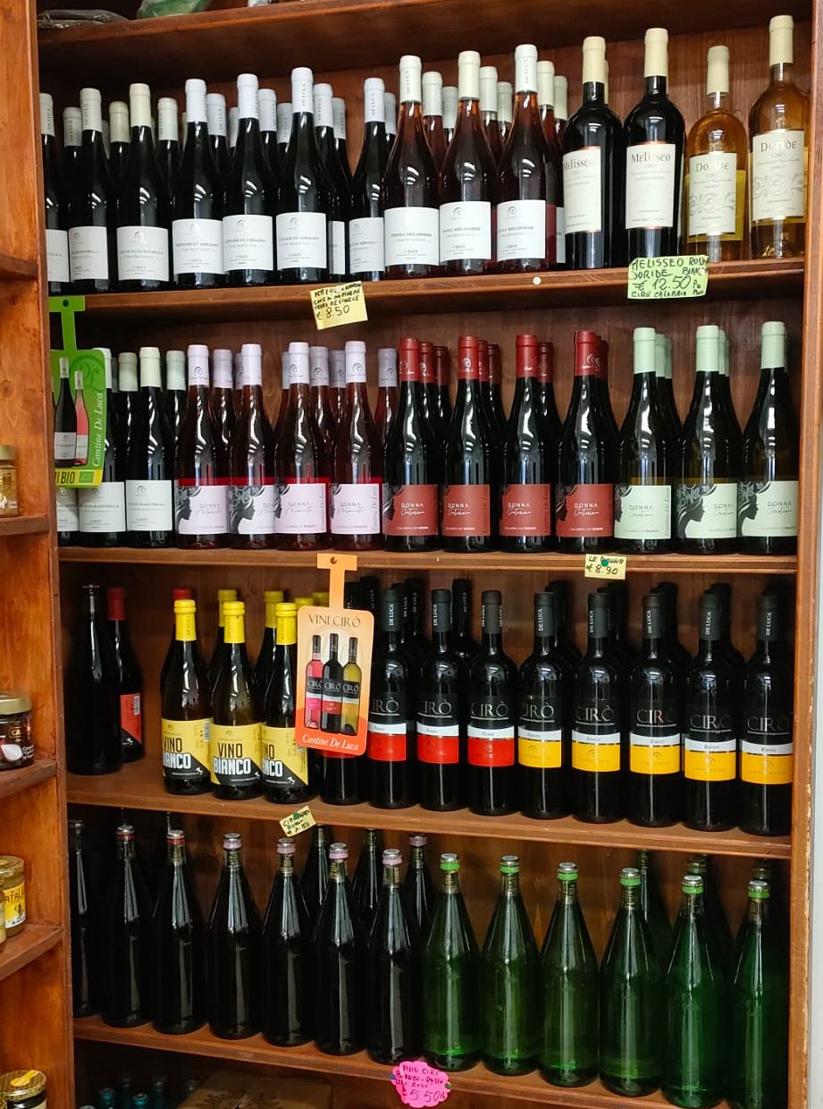 Lo scaffale dei vini di Natural Fruit con le bottiglie di Cirò e delle cantine calabresi